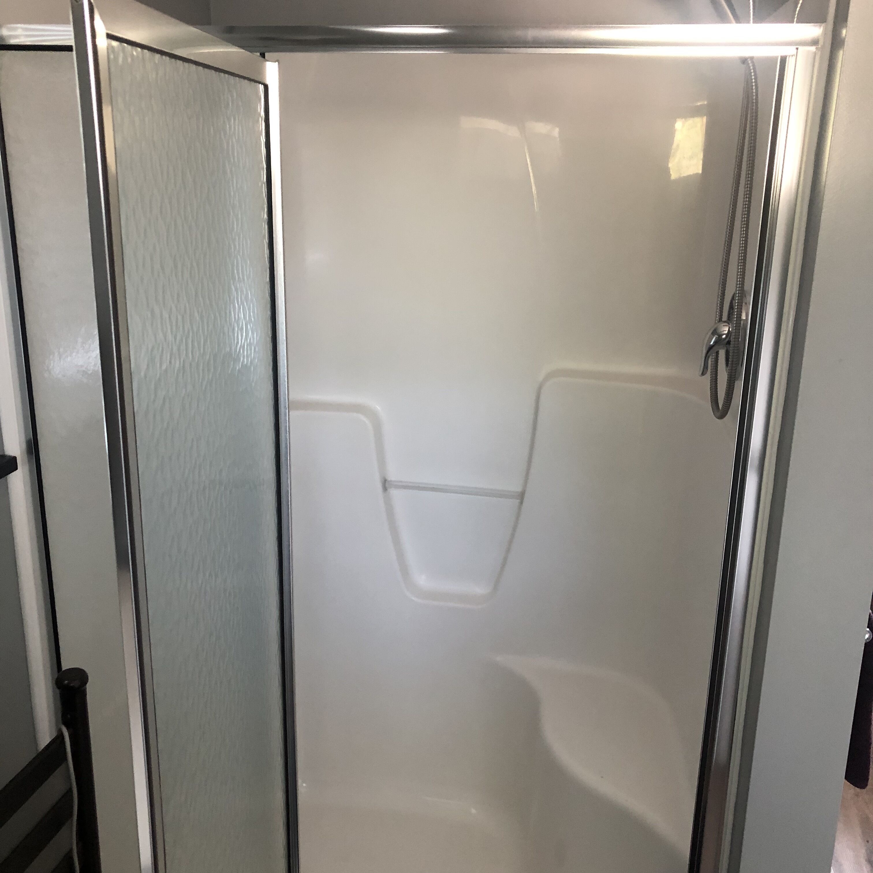 Box doccia con porta in vetro e soffione.
