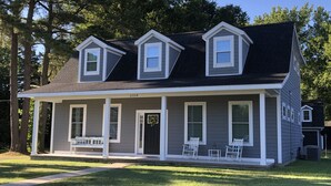 A two-story house with a front porch, numbered 23314, and two rocking chairs on the porch. - Newly Constructed Second Floor Modern Studio Apartment Unit 2 ~ Sleeps 6 (Accomac)