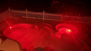 A hot tub area with a wooden deck and a circular hot tub. - Vacation home within walking distance to Bowman Beach (Sanibel)