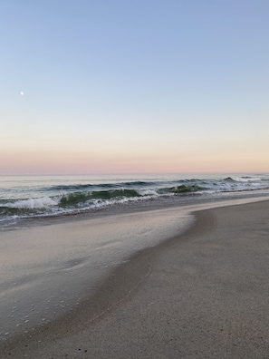 A beach with waves and a clear sky.