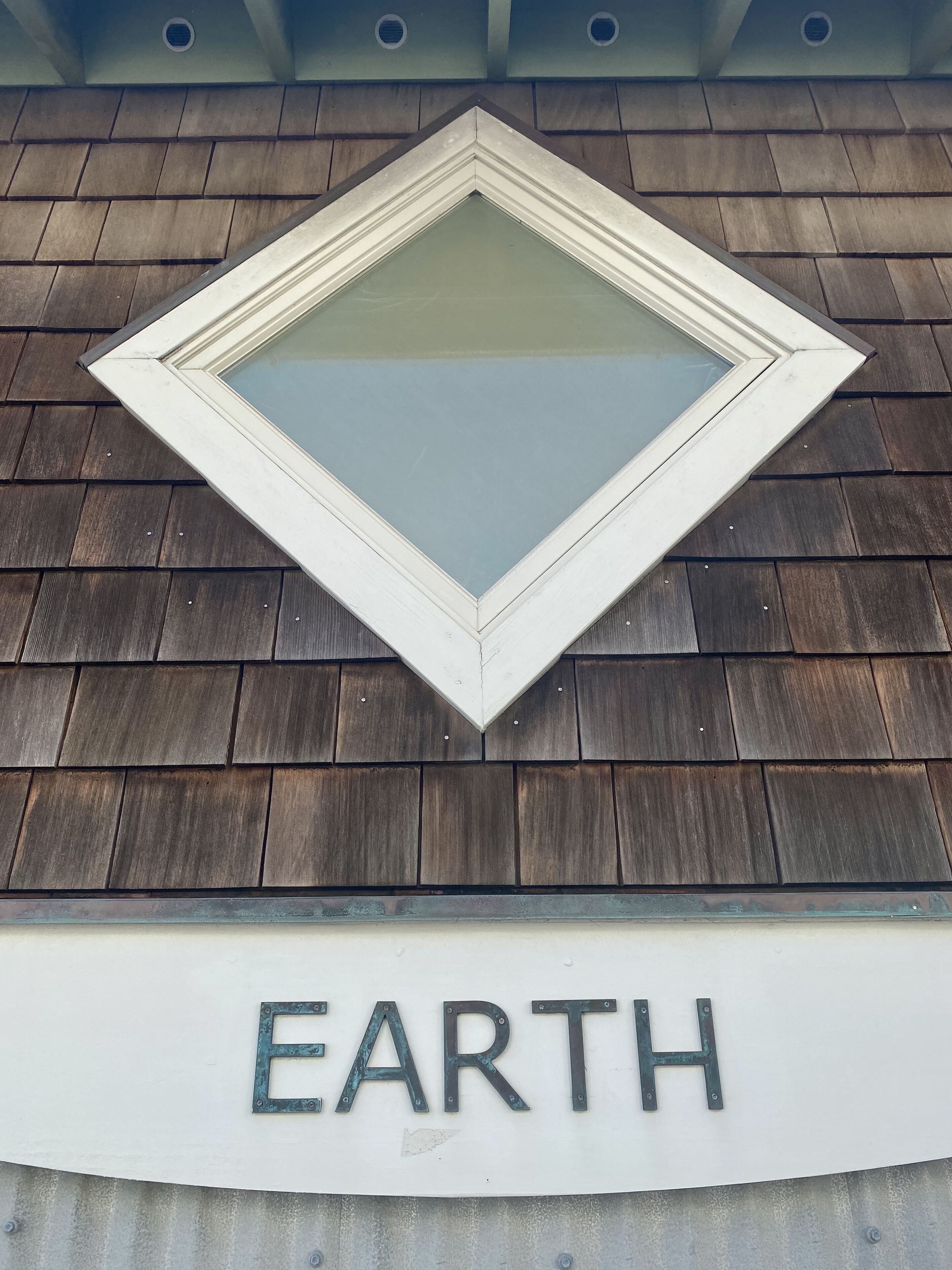 Un tragaluz con forma de diamante y un letrero debajo que dice "EARTH".