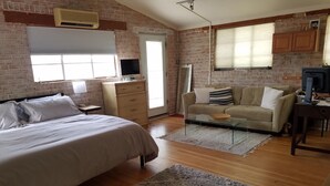 A bedroom with a bed, a dresser, a sofa, a TV, and a desk. - Tranquil Desert Retreat (Tucson)
