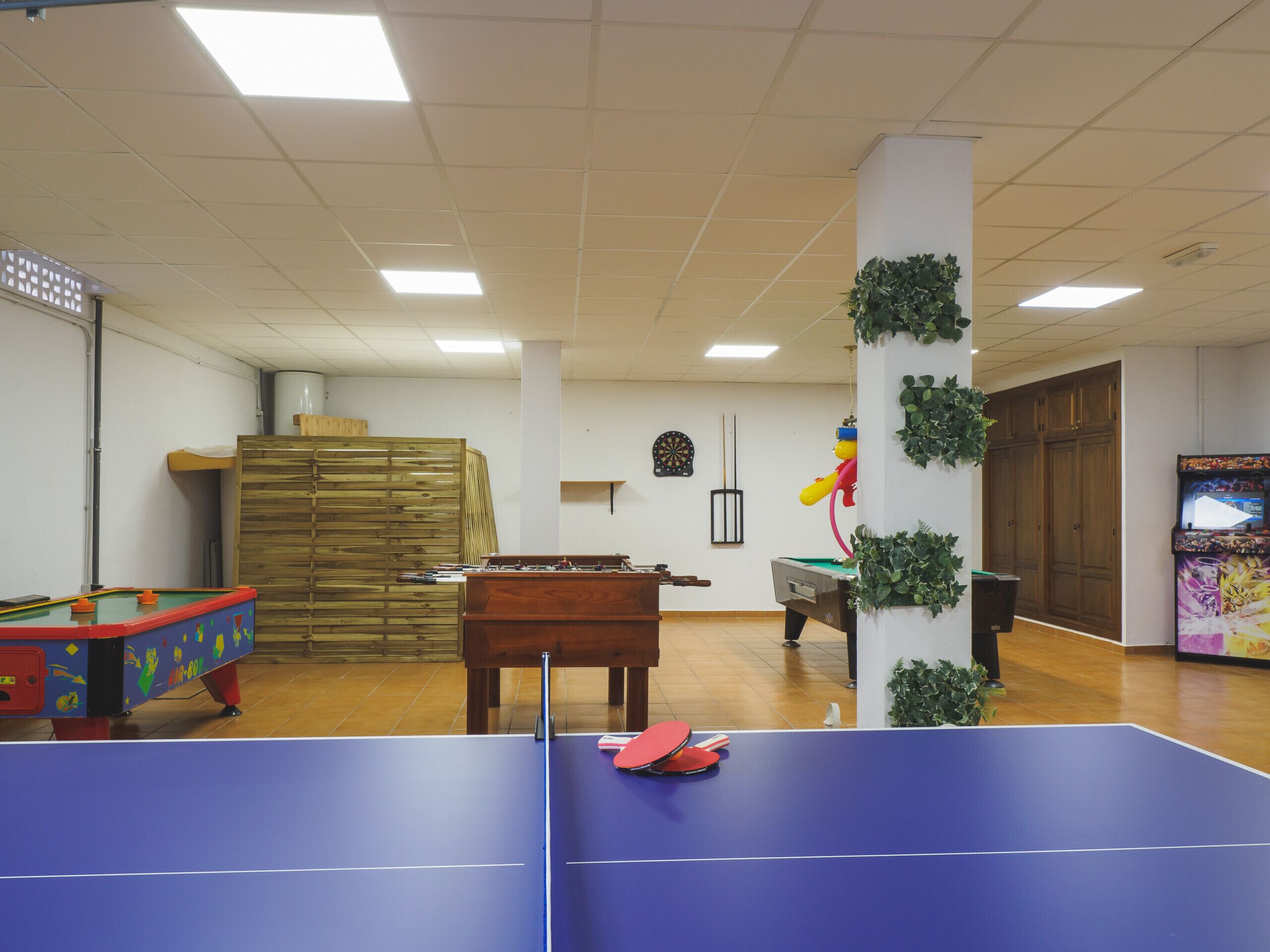 Une pièce équipée d’une table de ping-pong, d’un baby-foot et d’un jeu de fléchettes.