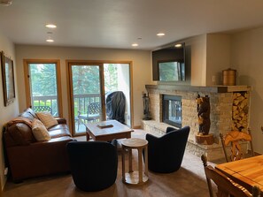 Enjoy a warm and inviting living space with a fireplace, comfortable seating, and stunning views through large windows.