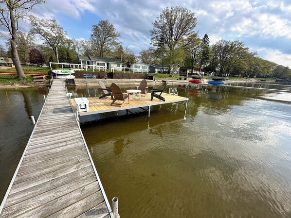 A dock with a seating area, a small table, and a cooler.