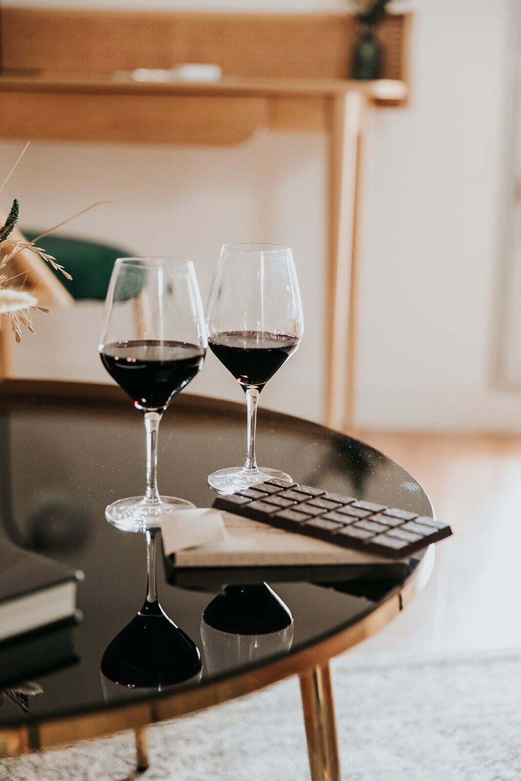 Una mesa de vidrio con dos copas de vino y un teclado.