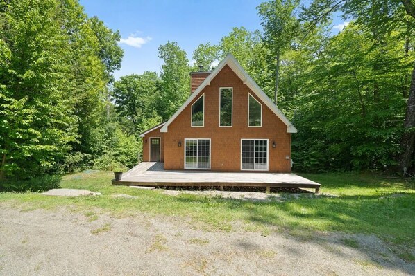 A single-story brick house with a gabled roof, large windows, and a front porch.