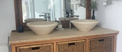 Ein Holzlagerflächezimmer mit zwei großen Waschbecken, einem Spiegel und einer Deckenleuchte.