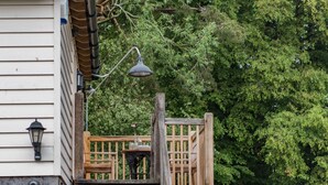 A wooden deck with a table and chairs, a hanging lantern, and a brick wall. - Motor House Loft - beautiful loft conversion in lovely rural location by Bloom Stays (Sandhurst)