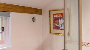 Casa de banho com um quadro na parede, um porta-toalhas e zona de duche.
