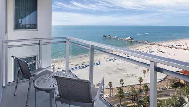 Un balcón con vista a una playa y un muelle.