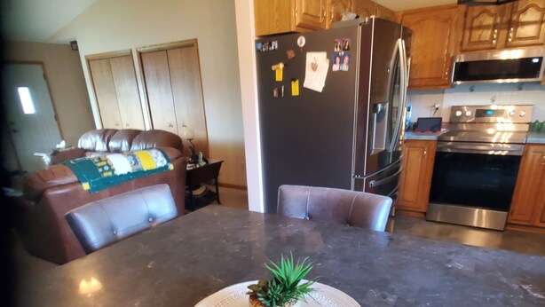 A kitchen with a central island, wooden cabinets, stainless steel appliances, and a ceiling fan. - NFL Draft: Close to Lambeau and Appleton & Oshkosh airports. Sleeps  8+ (Appleton)