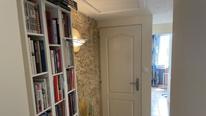 Ein Flur mit Bücherregal, Tür und Lampe.