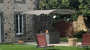 A stone house with a grassy yard, outdoor seating, and a large tree. - 3-bedroom vacation home. Le Faou Aulne Maritime Crozon  (LE FAOU)