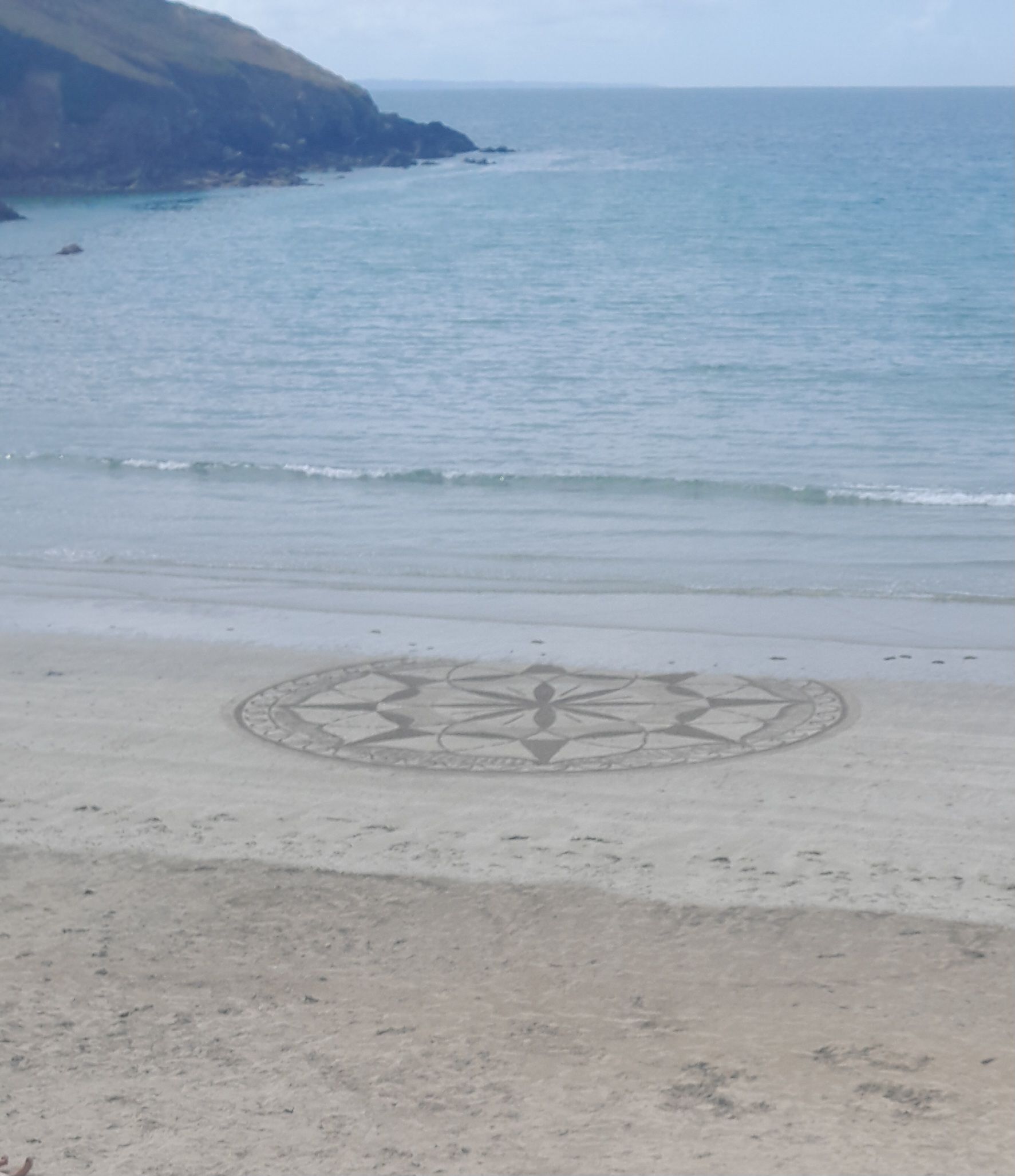 A beach with a circular pattern on the sand.