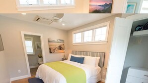 A bedroom with a bed, a window, a ceiling fan, and a wardrobe. - Cottages with easy access to Newport, beaches, nature trails  and  vineyards (Middletown)