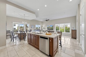 A spacious kitchen with a central island, large windows, and a ceiling fan. - At Sun Sea Terrace | Luxury Siesta Key Condo w/ Heated Pool, Short Walk to Beach and Village (Siesta Key)