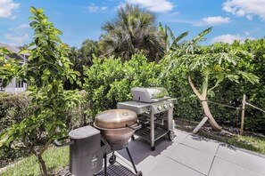 Enjoy al fresco dining in a serene outdoor setting with a grill and patio.