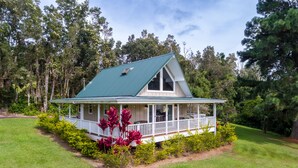 A house with a green roof, white exterior, and a porch with a railing. - Private Country Cottage | 2+ Bedroom on 1-acre | 5 mins to Kamuela town (Waimea)