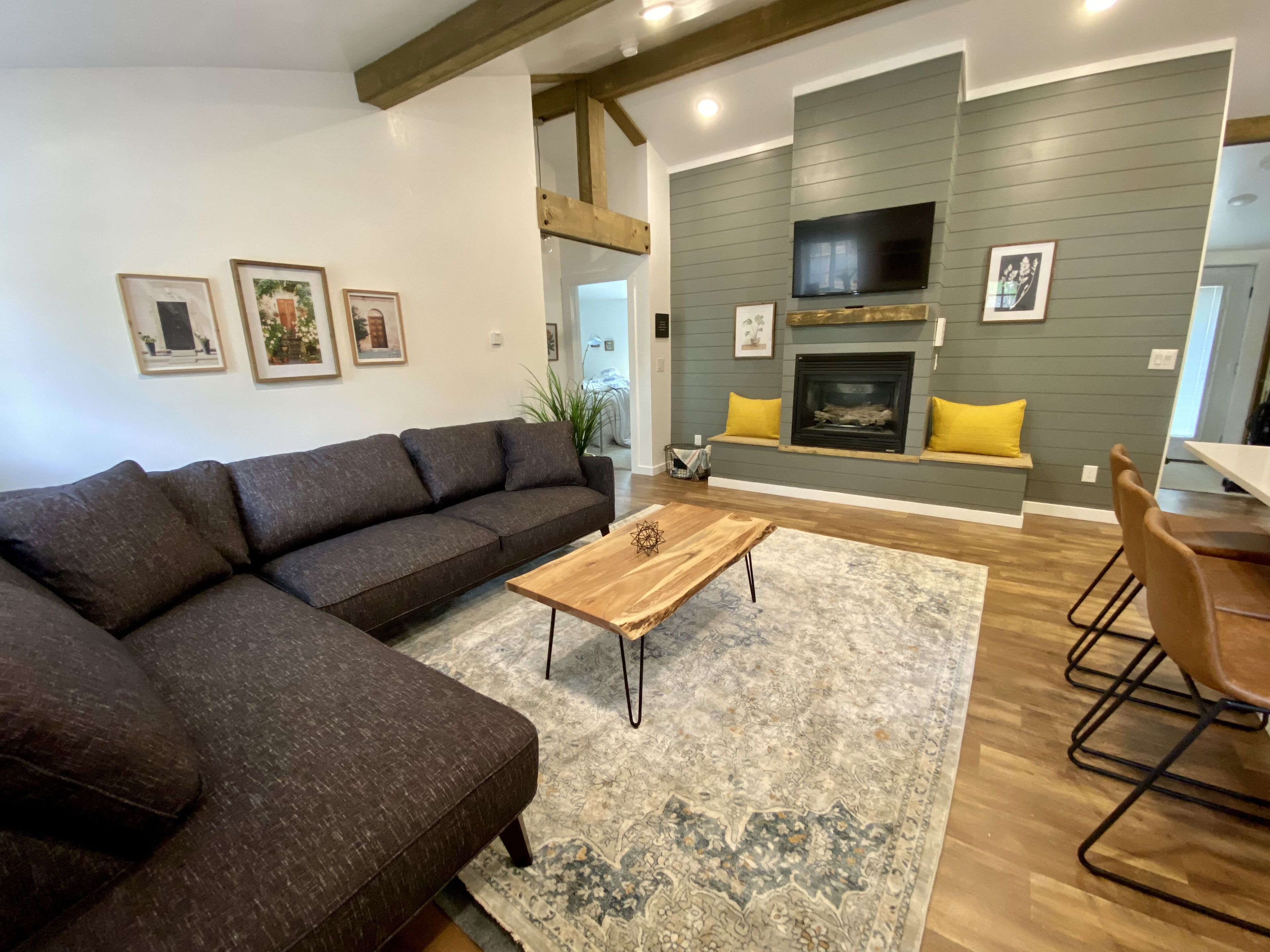 A modern living room with a sectional sofa, a wooden coffee table, and a fireplace.