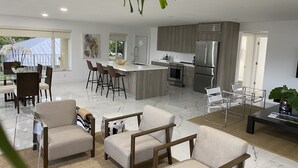 A modern kitchen with a central island, stainless steel appliances, and a dining area with bar stools. - Waterfront condo overlooking Palm Beach (West Palm Beach)