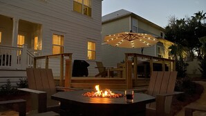 Un patio con una chimenea, muebles de exterior y una sombrilla.