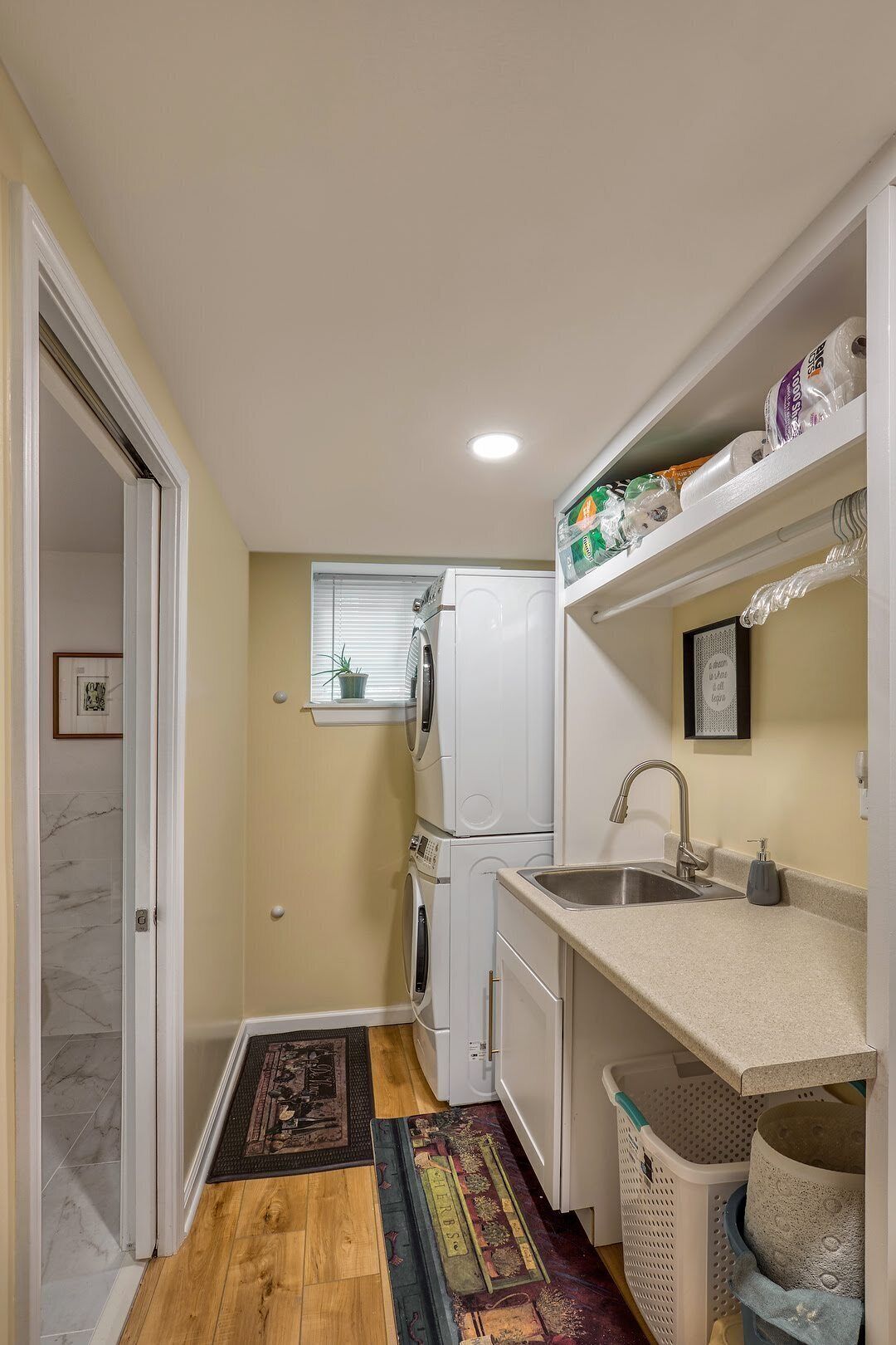 A compact kitchen with a sink, a refrigerator, and a window.