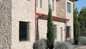 A stone building with a flat roof, multiple windows, and a paved driveway. - Casa Adele 1 per una Vacanza in Semplicità e Relax (Itri)