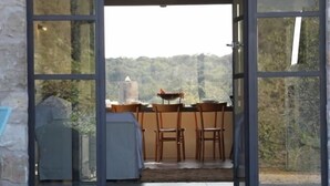 A modern outdoor dining area with a stone wall, a covered grill, and a table with chairs. - Casa Adele 1 per una Vacanza in Semplicità e Relax (Itri)