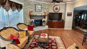 A living room with a fireplace, a television, and a dining area. - Lake Front Estate w/Private Boat Dock on 15 acres - One of a kind! (Alba)
