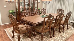 A dining room with a large wooden table, ornate chairs, a mirror cabinet, and a chandelier. - Lake Front Estate w/Private Boat Dock on 15 acres - One of a kind! (Alba)