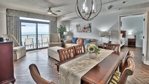 A spacious living room with a dining area, large windows, and a view of the ocean. - 5-Star Luxury, Fully Updated OCEANFRONT 2 Bed/ 2 Bath FALL STAYS 50% OFF RESORT! (Myrtle Beach)