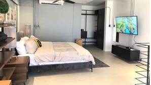 Una camera da letto moderna con un letto, una ventola a soffitto, una televisione e un armadio.