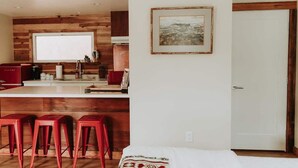 Een moderne keuken met houten details, een groot raam en een ingelijst beeld aan de muur.