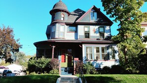 Ein Haus im viktorianischen Stil mit Erker, Türmchen und einer Veranda.