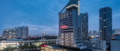 A modern hotel with a distinctive curved facade and a prominent 'Hampton' sign.
