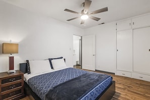A bedroom with a bed, a nightstand, a ceiling fan, and a wardrobe. - Ideal for Families & Groups (Chico)