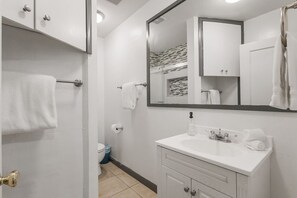 Ein Badezimmer mit Waschbecken, Spiegel und Toilette.