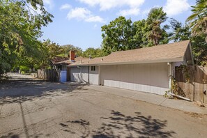 A single-story house with a garage, a driveway, and a wooden fence. - Charming Avenue Guest House (Chico)