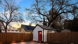 A residential property with a fenced backyard, a shed, and a house with a red door. - Chic Guesthouse Near Downtown | Stylish, Private & Cozy (Chico)