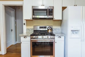 A kitchen with white cabinets, a stainless steel microwave, a gas stove, and a built-in oven. - Lovely House near Downtown, Your Home away from Home! (Chico)
