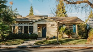 A two-story house with a front porch, a garage, and a well-maintained lawn.