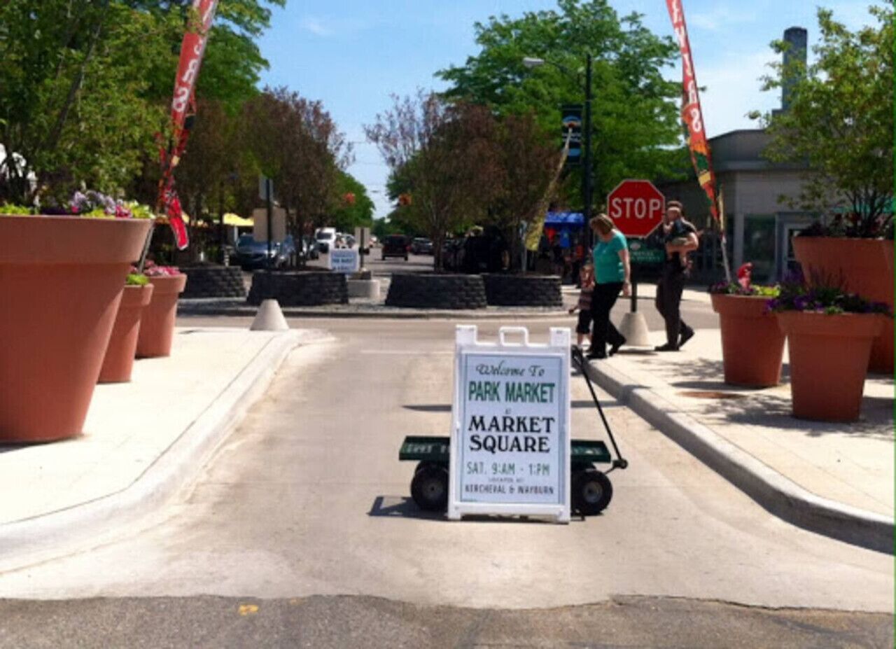 Eine Straße mit einem Schild für den Park Market Market Square, das anzeigt, dass er samstags von 9 bis 13 Uhr geöffnet ist.