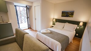 A hotel room with a bed, a sofa, a desk, and a window with a view of a bridge. - Studio for 2 people * SPA * River view (Adaúfe)