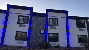 Un bâtiment moderne composé de trois sections, chacune dotée d’une grande fenêtre et d’un petit appareil de climatisation.