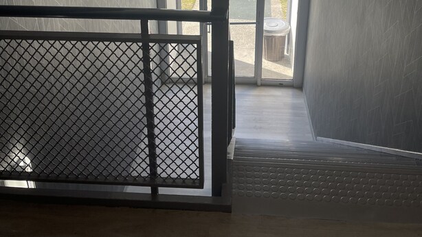 Un intérieur moderne donnant sur un parking, la vue étant accessible par une porte vitrée.