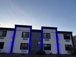 A modern building with a symmetrical facade, featuring rectangular windows and a central vertical element.