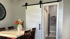A dining area with a marble table, wooden chairs, and a vase of flowers. - Country Living in the City (Mesa)