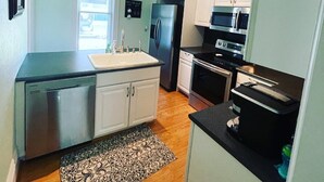 A compact kitchen with a refrigerator, microwave, stove, and dishwasher. - Riverwalk Retreat on Main. Spacious updated Victorian Home in the heart of Niles (Niles)