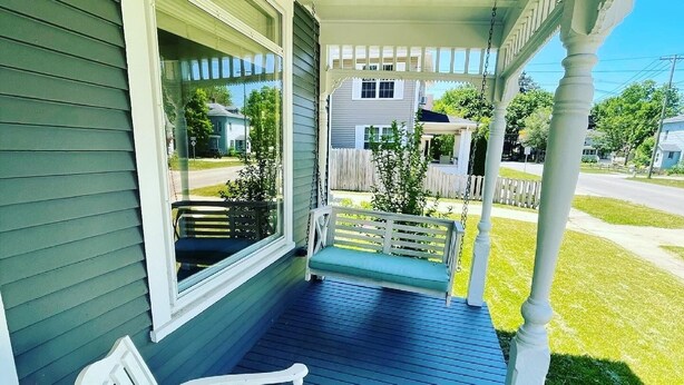 A porch with a bench, a swing, and a view of a residential street. - Riverwalk Retreat on Main. Spacious updated Victorian Home in the heart of Niles (Niles)